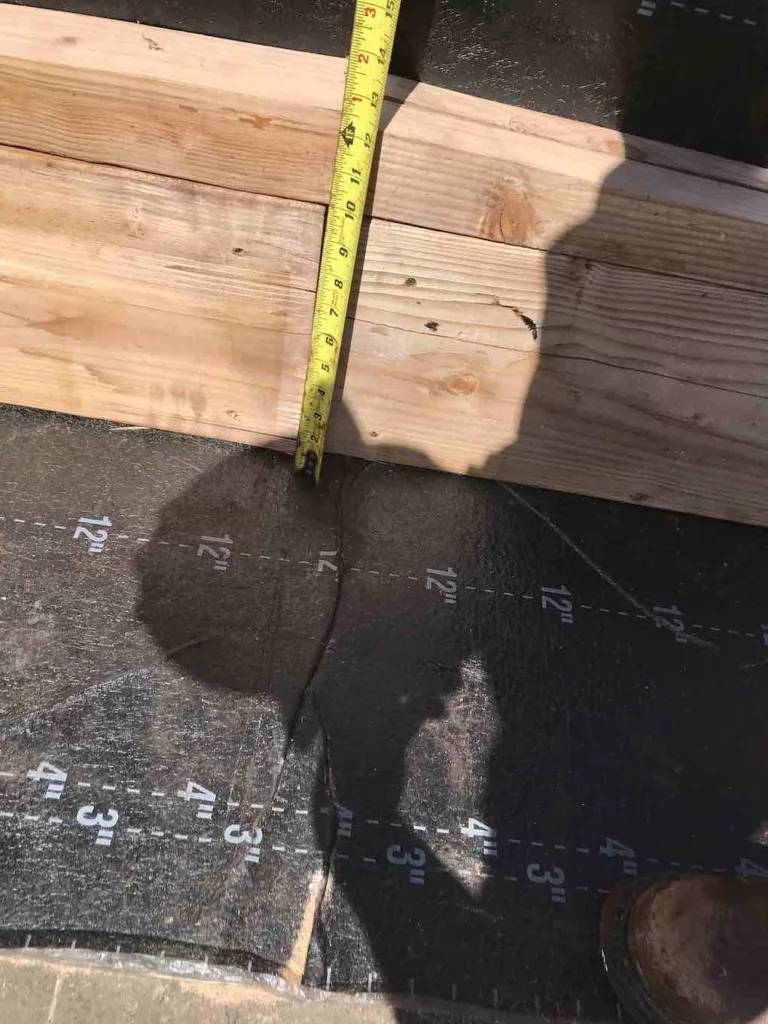 Documenting the height of the roof peak for construction quality control purposes.